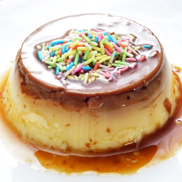 Crème caramel gegarneerd met hagelslag van verschillende kleuren — Stockfoto