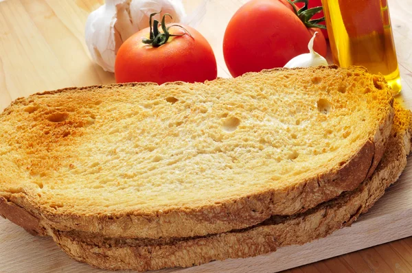 Toastbrotscheiben, Knoblauch, Olivenöl und Tomaten — Stockfoto