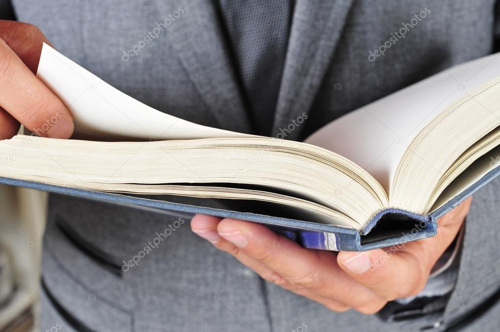 man in suit reading a book