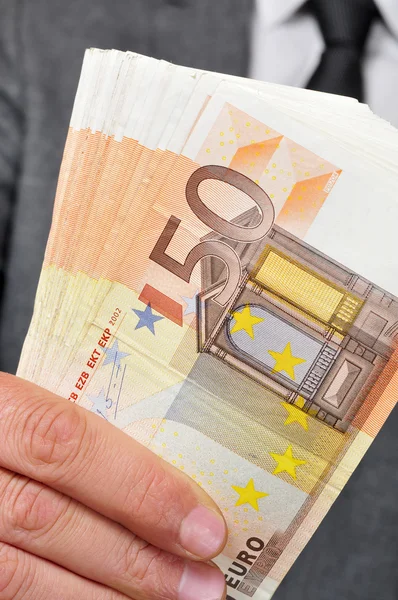 Man in suit with a wad of euro bills — Stock Photo, Image