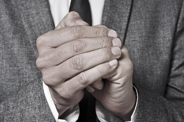 Uomo in giacca e cravatta strofinando le mani — Foto Stock