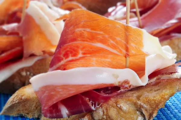 Spanish pinchos de jamon, serrano ham served on bread — Stock Photo, Image