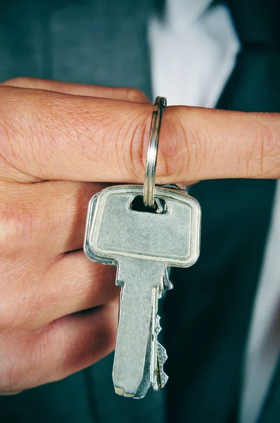 Man in suit showing a key ring — Stok fotoğraf