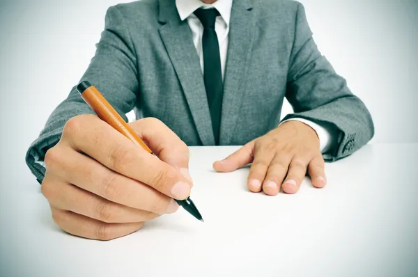 Man in pak met een pen in zijn hand klaar om te schrijven — Stockfoto