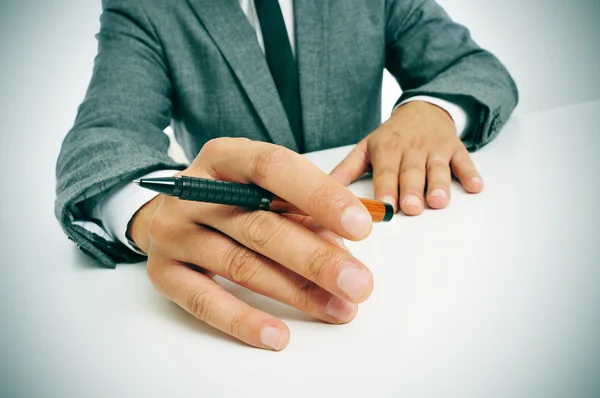 Uomo in giacca e cravatta con una penna in mano — Foto Stock