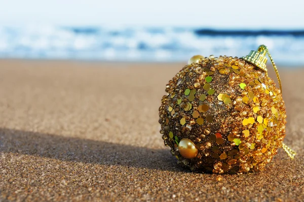 Christmas ball on the sand of a beach — Stock Photo, Image