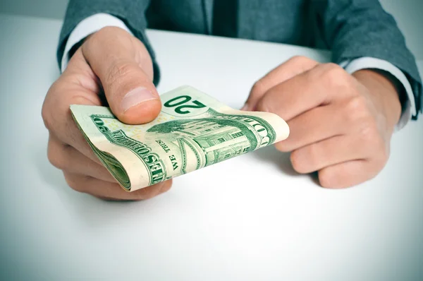 Man in suit with a wad of american dollar bills — Stock Photo, Image
