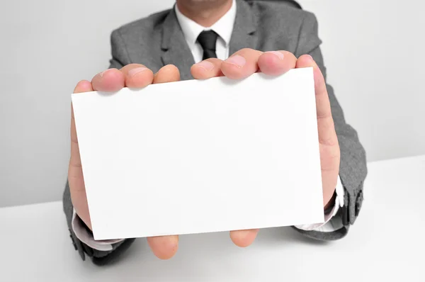 Uomo in giacca e cravatta con un cartello bianco — Foto Stock
