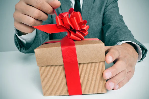 Man in suit opening a gift — Stock Photo, Image