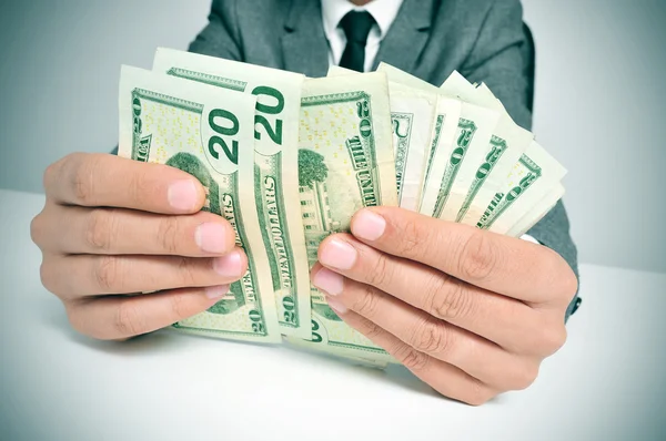 Man in suit counting US dollar bills — Stock Photo, Image