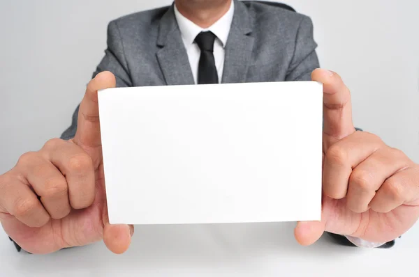 Man in suit holding a blank signboard — Stock Photo, Image