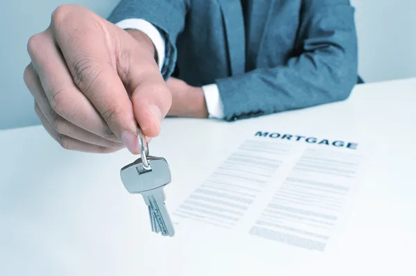 Man in suit giving the keys — Stock Photo, Image