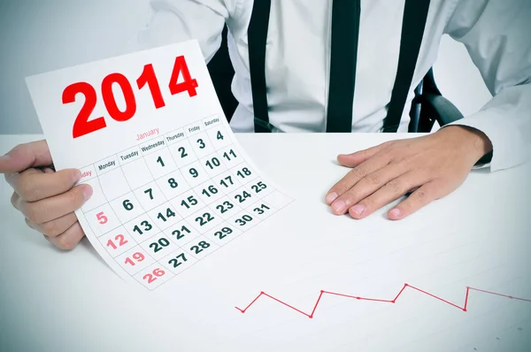 Uomo in giacca e cravatta con grafico e calendario 2014 — Foto Stock