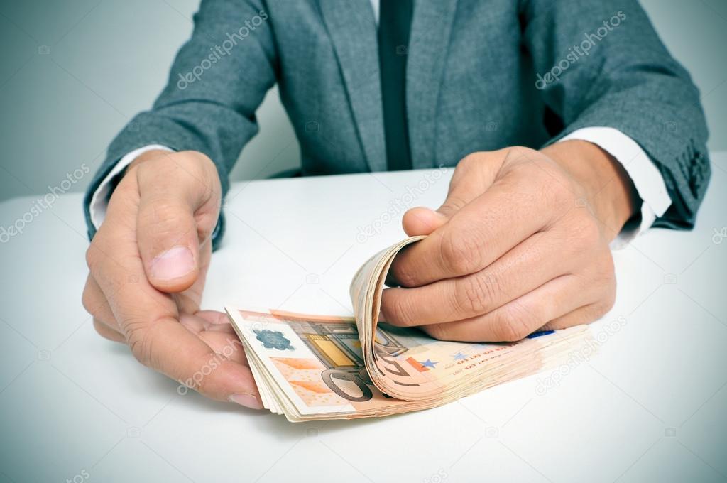 man in suit counting euro bills