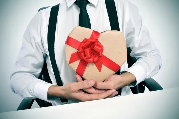 Geschäftsmann mit herzförmigem Geschenk — Stockfoto