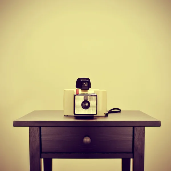 Old instant camera on a bureau — Stock Photo, Image