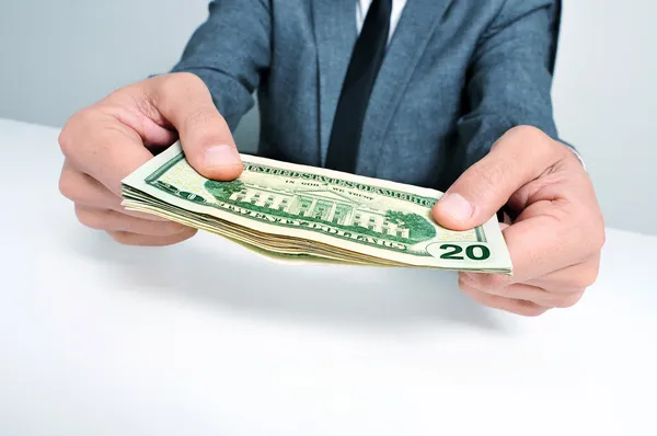 Man in suit with a wad of american dollar bills — Stock Photo, Image