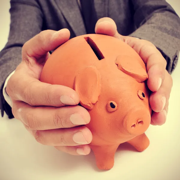 Man in pak met een piggy bank — Stockfoto