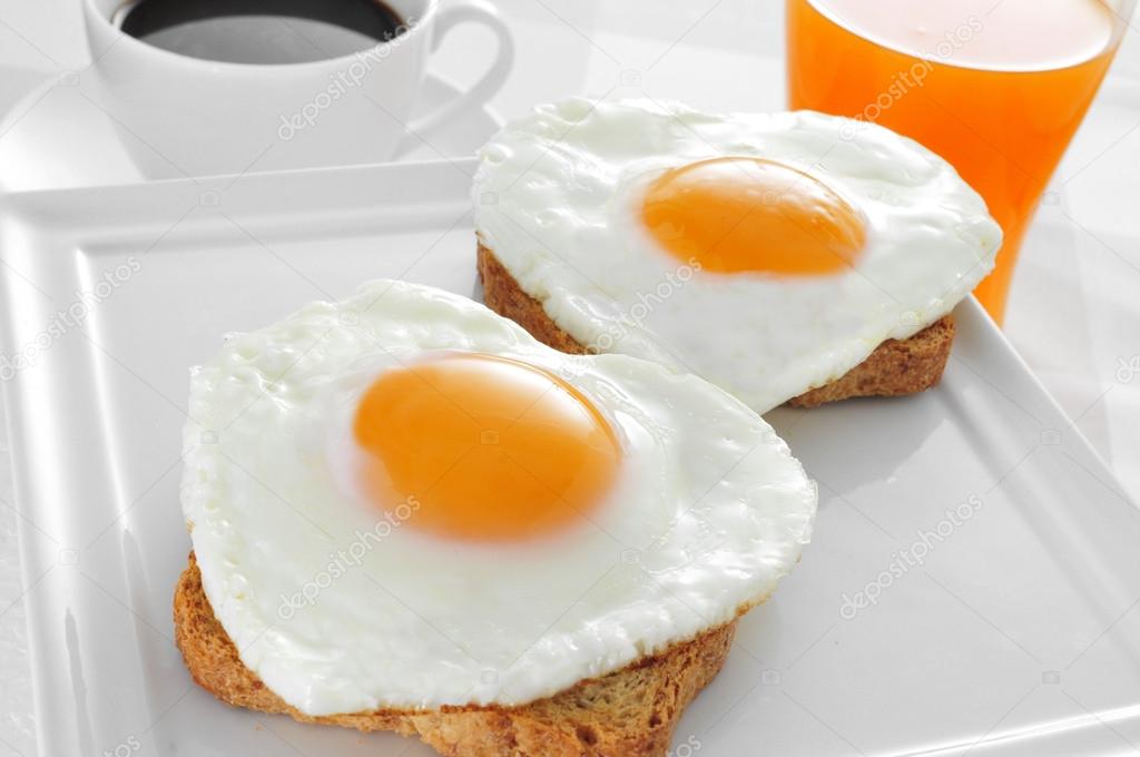 heart-shaped fried eggs, bread and orange juice