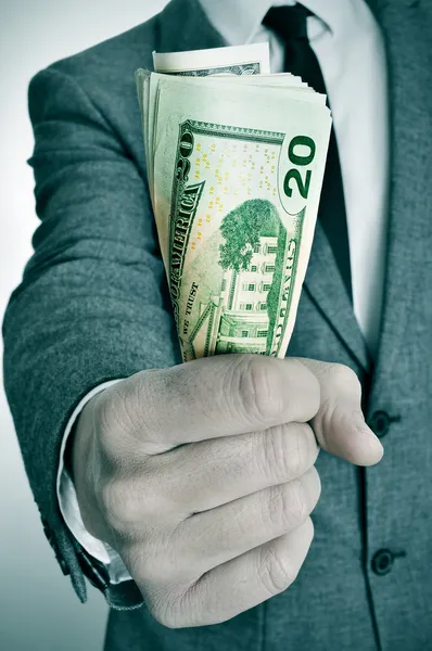 Homem de terno com um maço de notas de dólar americano — Fotografia de Stock
