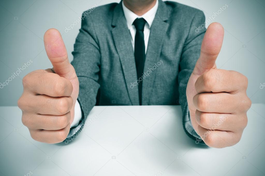 man in suit giving a thumbs up signal