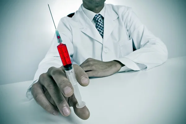 Médico sinistro com uma seringa — Fotografia de Stock
