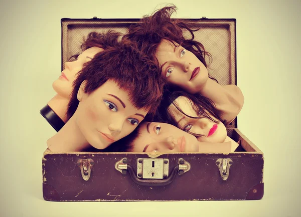 Mannequin heads in an old suitcase — Stock Photo, Image