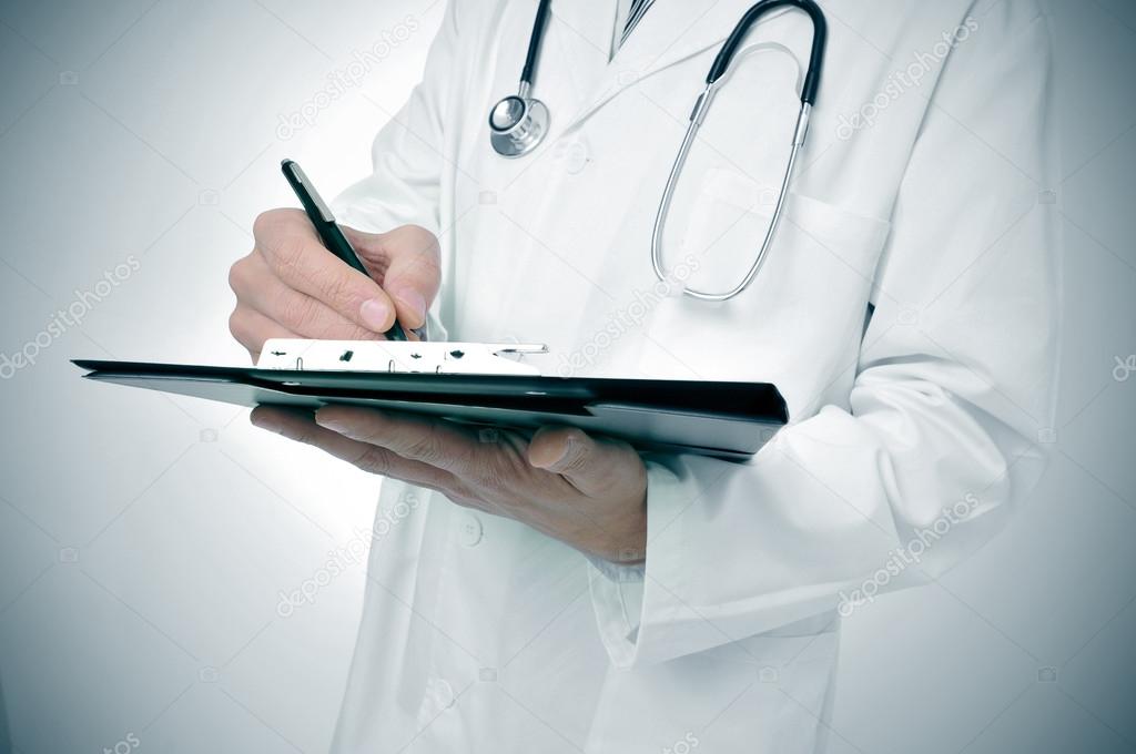 doctor writing in a clipboard