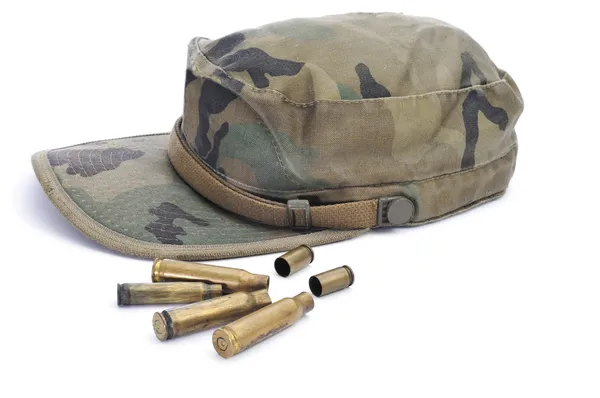 Camouflage cap and empty bullets — Stock Photo, Image