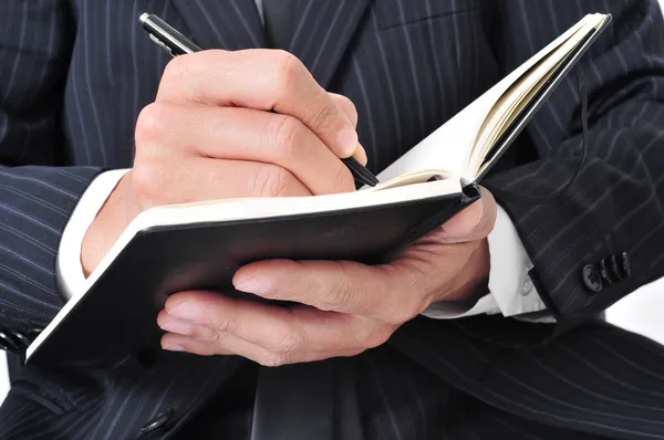 Empresario escribiendo en un cuaderno — Foto de Stock