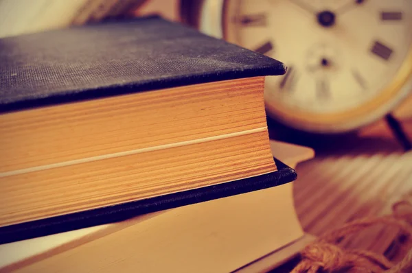 Oude boeken en een oude wekker, met een retro-effect — Stockfoto