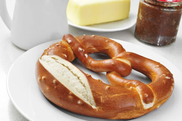 Un laugenbrezel, un bretzel allemand, sur une table dressée pour le petit déjeuner — Photo