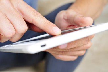 Genç adam tablet bilgisayar kullanıyor.