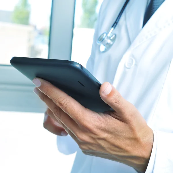 Doctor revisando su tableta en el hospital —  Fotos de Stock