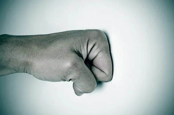 Punho homem perfurando uma superfície branca — Fotografia de Stock