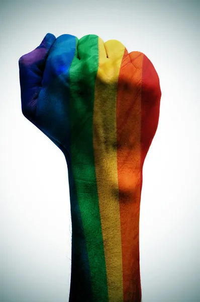 Raised fist patterned with the rainbow flag, symbolizing the fig — Stock Photo, Image