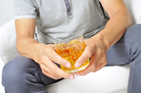 Junger Mann hängt mit einem Glas Schnaps herum — Stockfoto