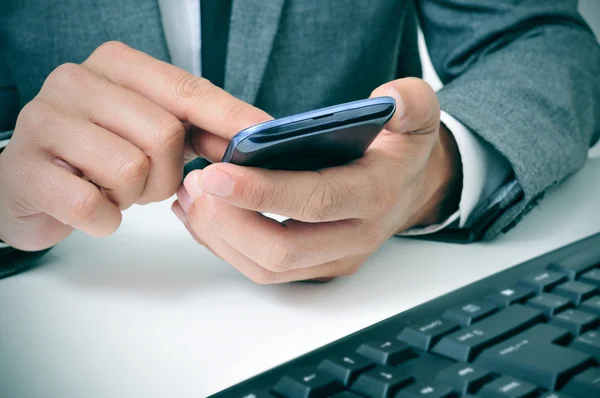 Empresário usando um smartphone no escritório — Fotografia de Stock