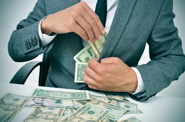 Mannen i kostym komma dollarsedlar i sin jacka — Stockfoto