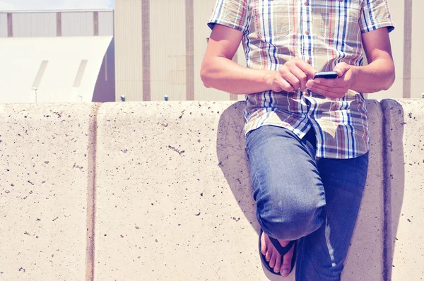 Молодой человек с помощью смартфона на улице — стоковое фото