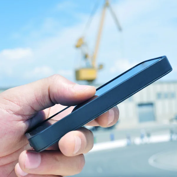 Mann mit Smartphone im Industriepark — Stockfoto