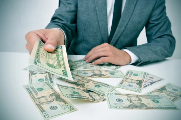 Man in suit giving dollar bills — Stock Photo, Image