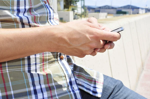 Jeune homme utilisant un smartphone à l'extérieur — Photo