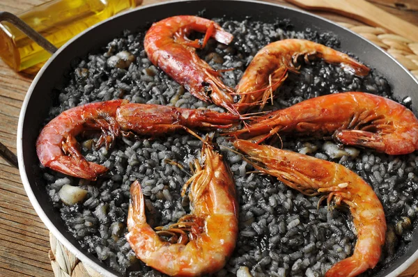 Spanish arroz negro, a typical rice casserole made with squid in — Stock Photo, Image