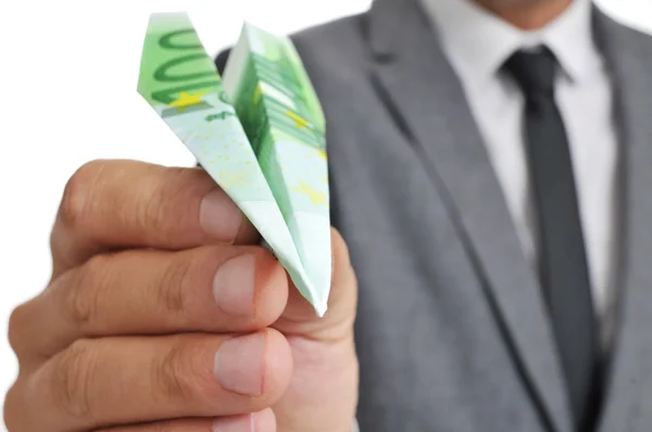 Empresário com um avião de papel feito com um banco de 100 euros — Fotografia de Stock