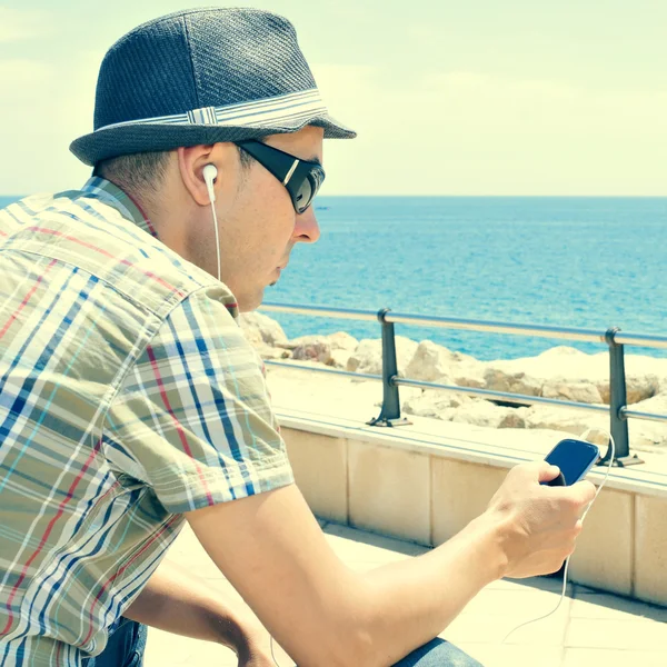 Jonge man muziek beluisteren of praten met koptelefoon in een sma — Stockfoto