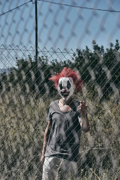 Skrämmande Ond Clown Med Rött Hår Som Gömmer Sig Utomhus — Stockfoto