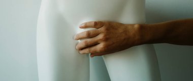 Genç beyaz bir adam, beyaz bir erkek mankenin kasıklarını eliyle örterek panoramik bir formatta web pankartı ya da başlık olarak kullanır.