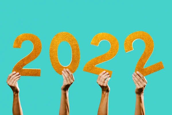 男人们手牵着一些金色的三维数字 组成数字2022 作为新年 蓝色背景的特写镜头 — 图库照片
