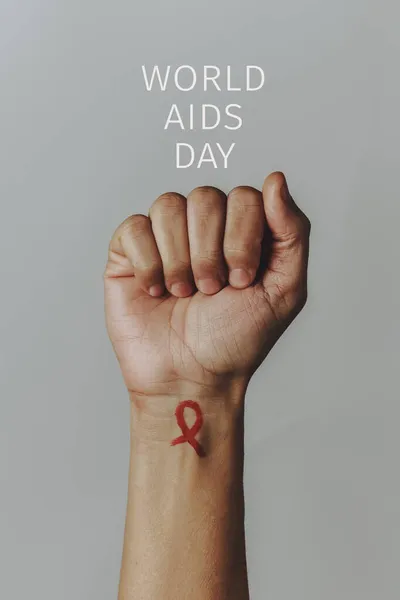 Closeup Raised Fist Man Red Awareness Ribbon Painted His Wrist — Stock Photo, Image